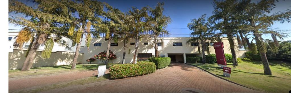 a large white building with trees and a driveway at MOTEL SENSUALE in Valinhos