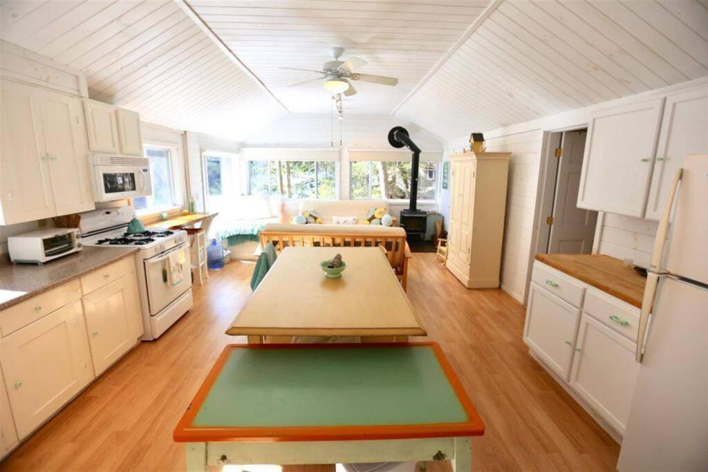 une cuisine avec une table au milieu dans l'établissement Hobie's Landing - Blissful lake side cottage - On Lake Winona, à Ashland