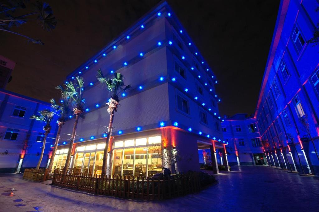 平鎮區的住宿－愛錸休閒精品旅館，建筑上点着蓝色和红色的灯光