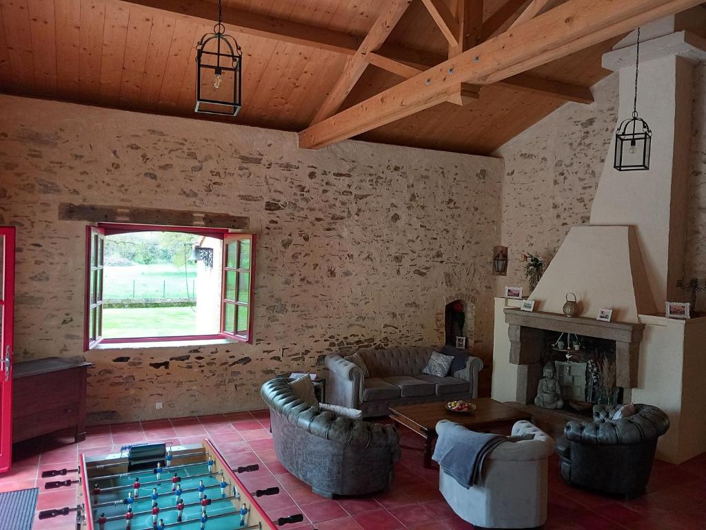 a living room with a couch and a fireplace at Gite La Minoterie - Piscine & spa 