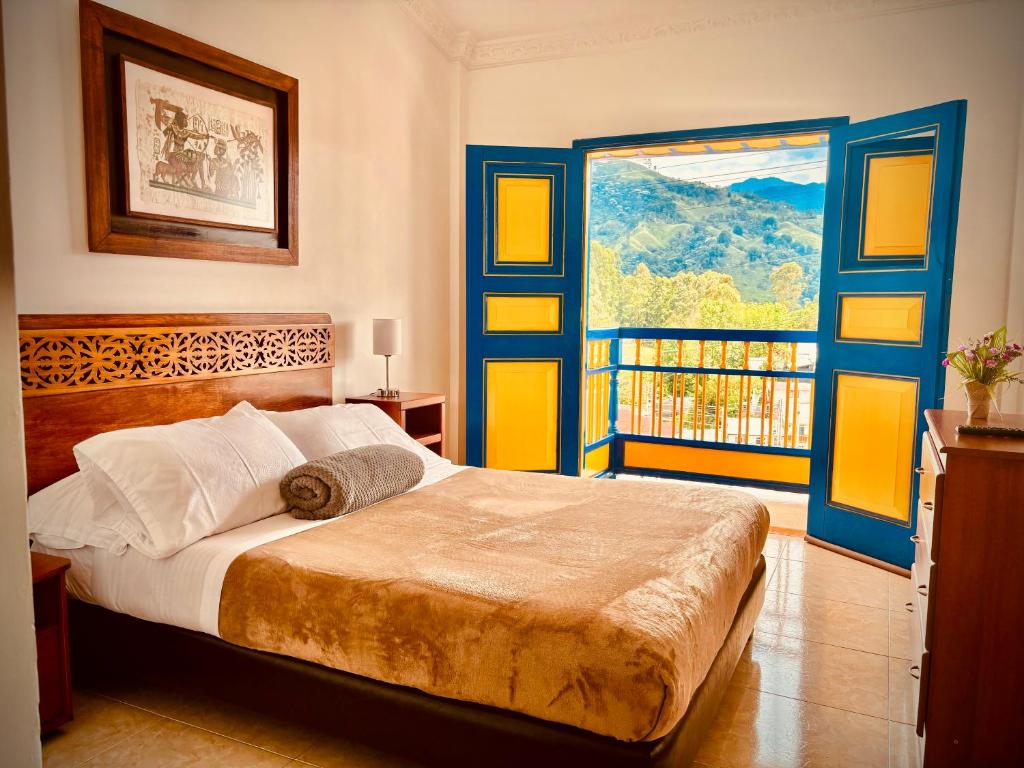 um quarto com uma cama e uma grande janela em Hospedaje Camino Real a 150 MTS del centro em Salento