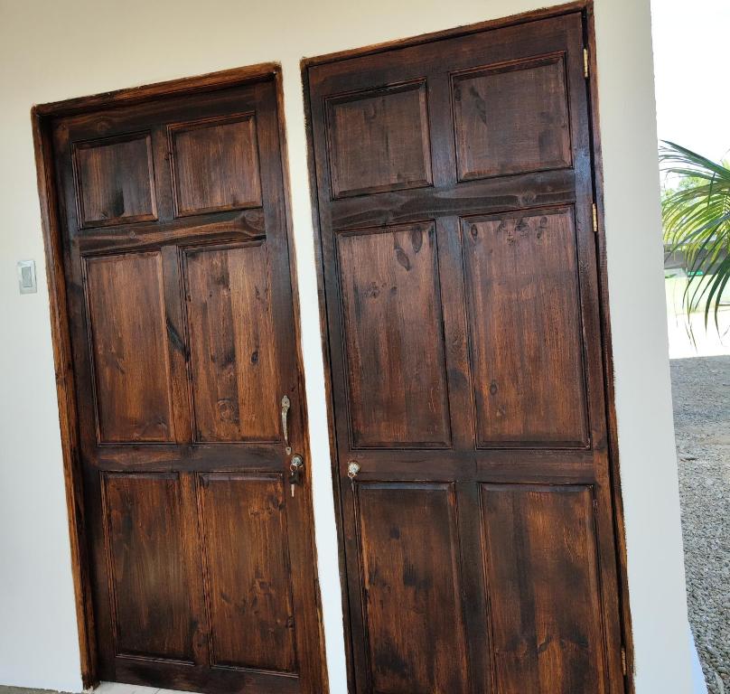 dwa drewniane drzwi są obok siebie w obiekcie Casa La Frontera w mieście Sixaola