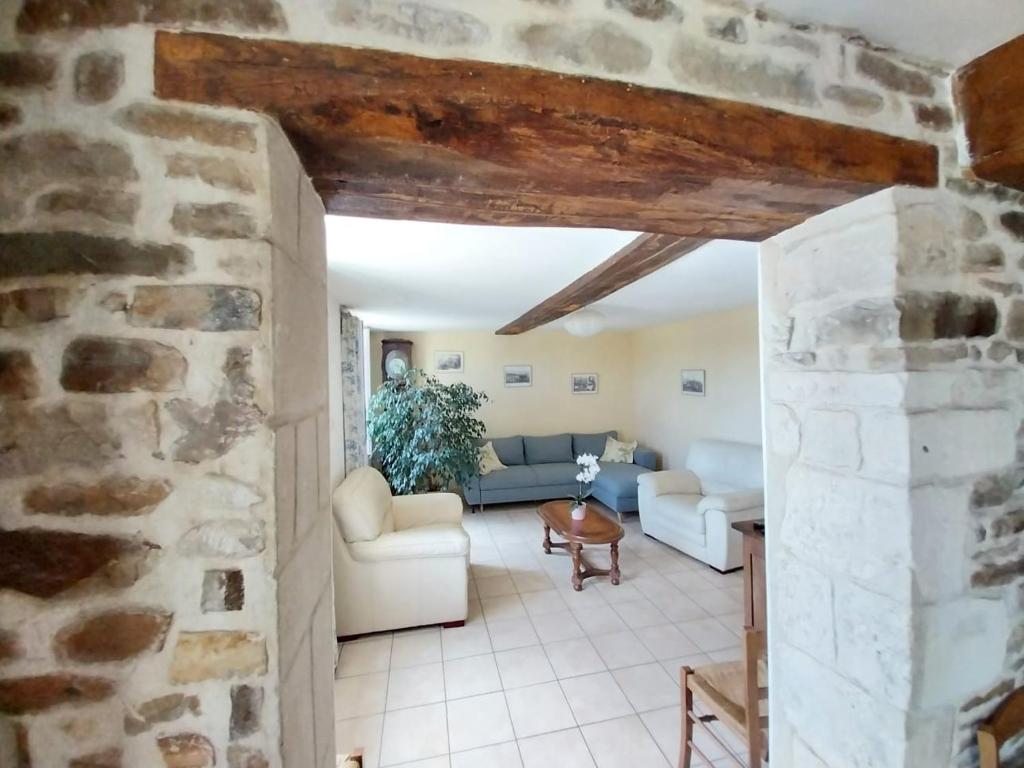 a living room with a stone wall at Entre forêts et prairies in Le Cercueil