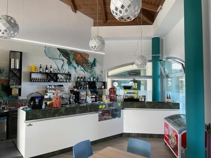 un ristorante con bancone e un bar con sedie blu di SUITE GARDEN-MARINA SVEVA a Marina di Montenero