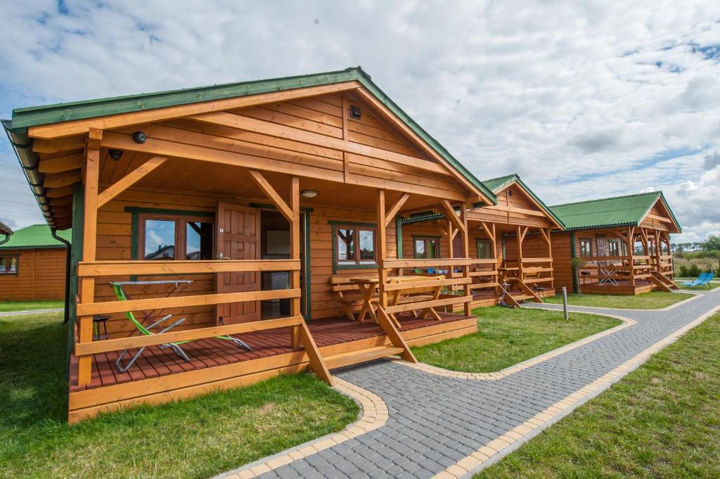 une rangée de cabanes en bois dans un parc dans l'établissement Lazur Apartamenty Domki, à Sarbinowo
