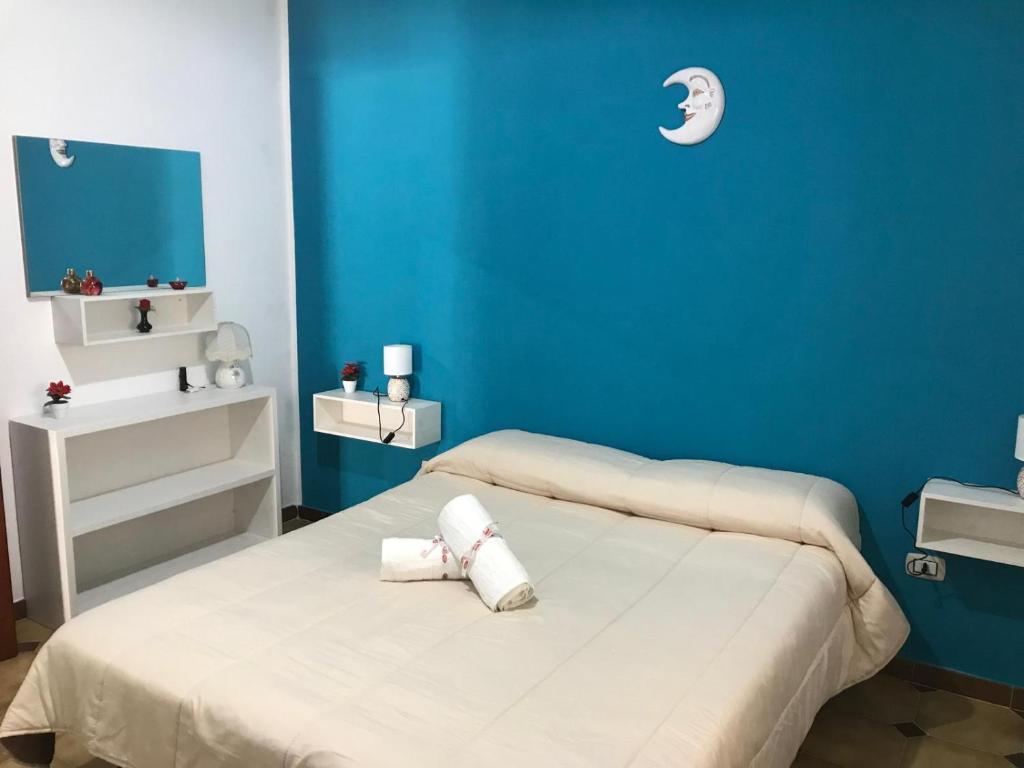 una camera blu con un letto e asciugamani di Villa "Ma Mi" Carloforte a Carloforte
