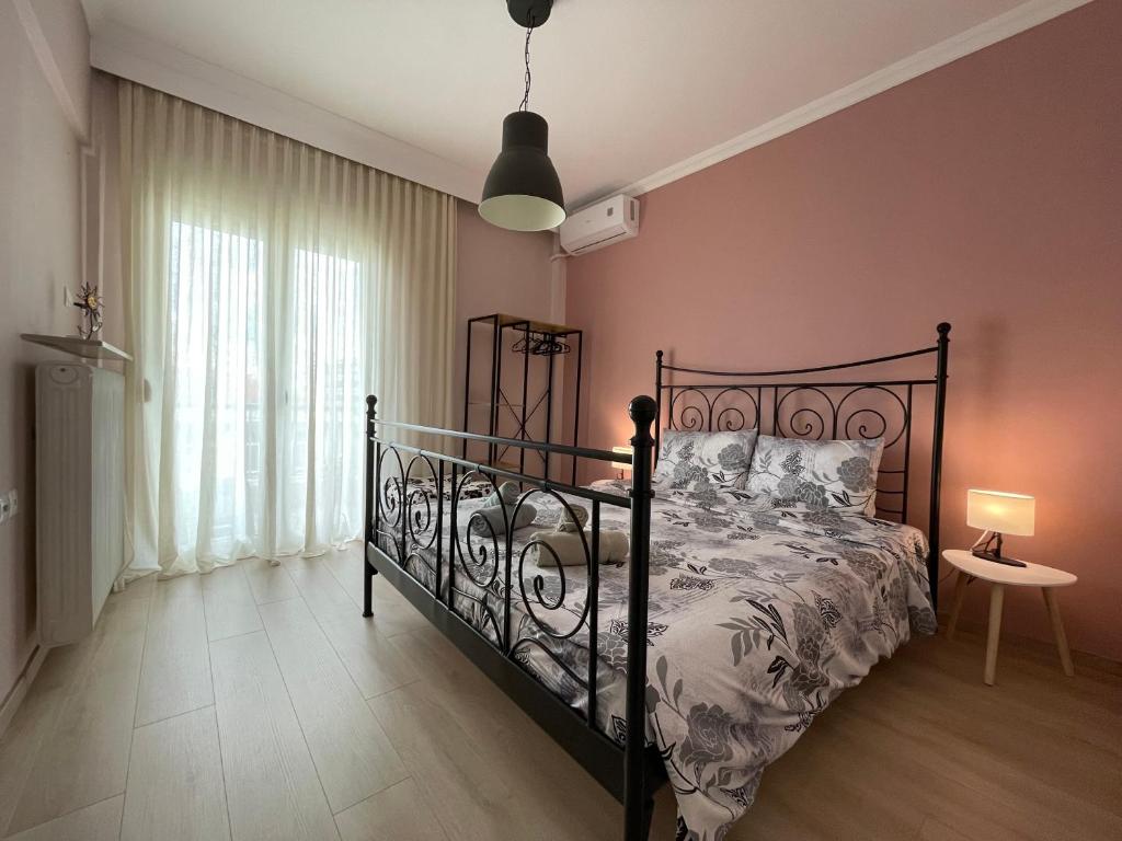 een slaapkamer met een zwart bed en een raam bij Asterios Home in Thessaloniki