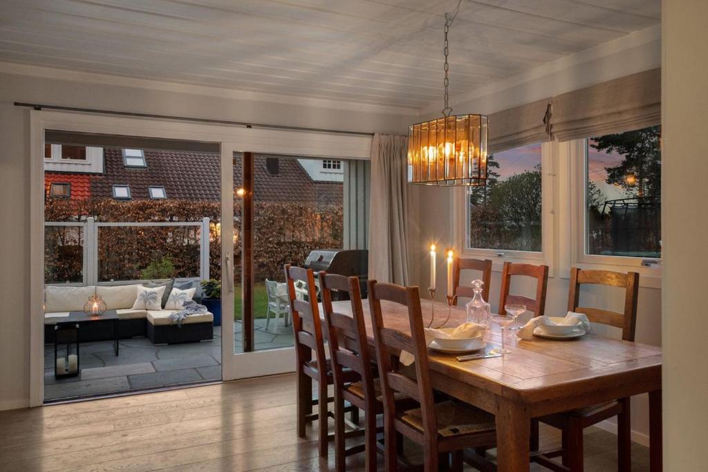 a dining room with a table and chairs and a room with a patio at Slemdal, Oslo West in Oslo