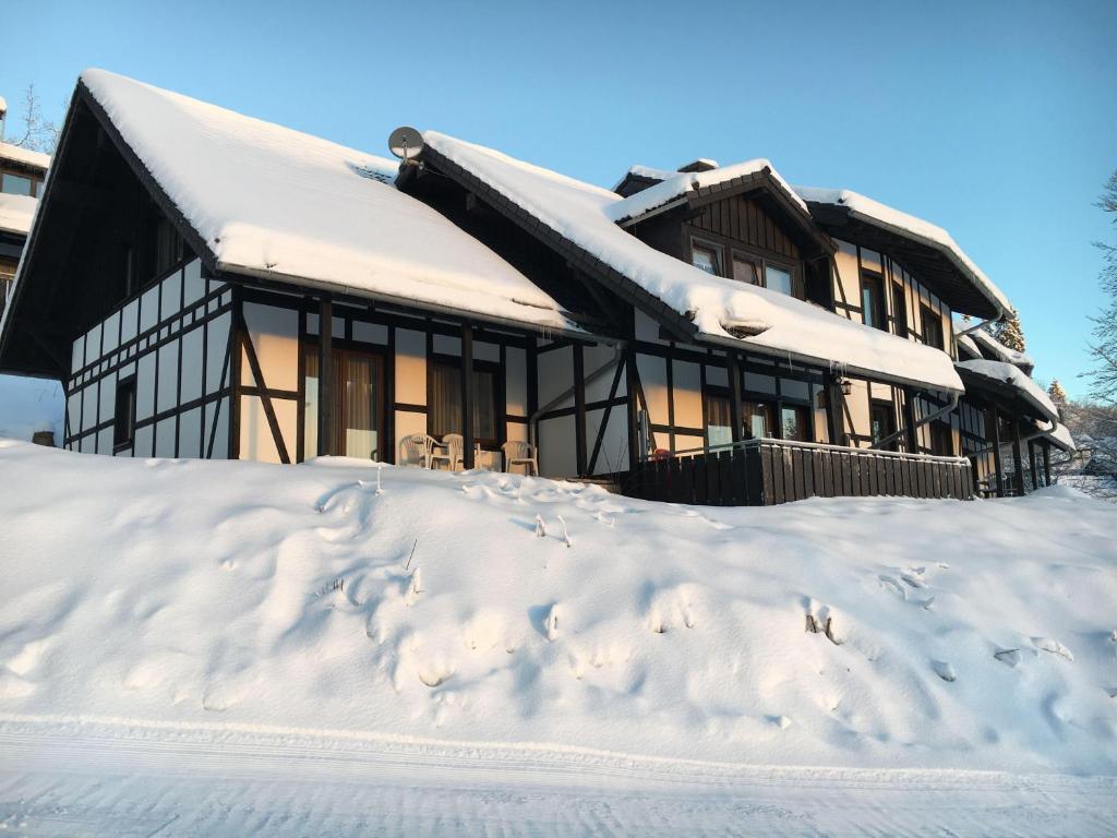 a house covered in snow with footprints in the snow at Landhaus-Postwiese in Winterberg