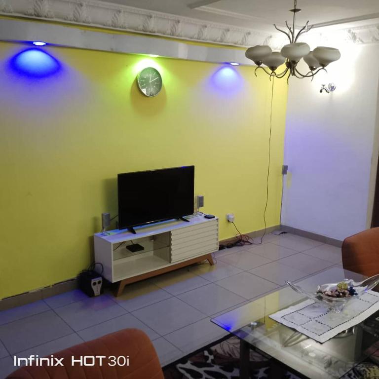 ein Wohnzimmer mit einem TV an einer grünen Wand in der Unterkunft Belle vue in Douala