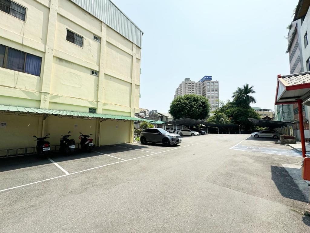 a parking lot with cars parked next to a building at Ai Lai Fashion Hotel in Taichung