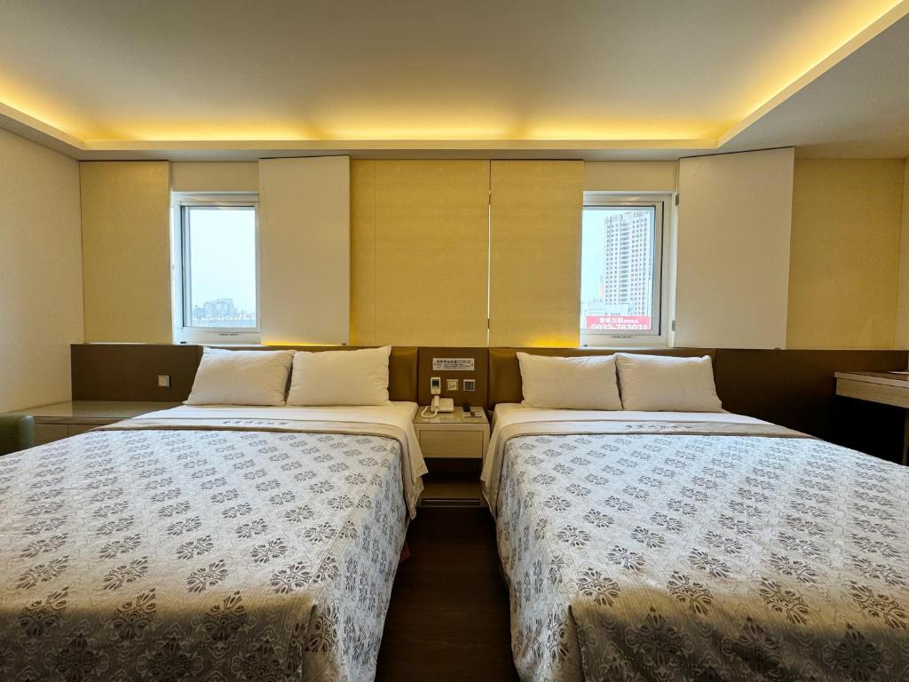 two beds sitting next to each other in a room at Ai Lai Fashion Hotel in Taichung