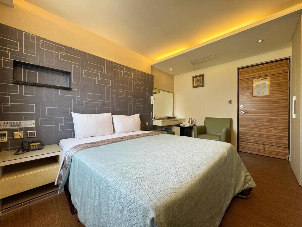 a hotel room with a large bed and a desk at Ai Lai Fashion Hotel in Taichung