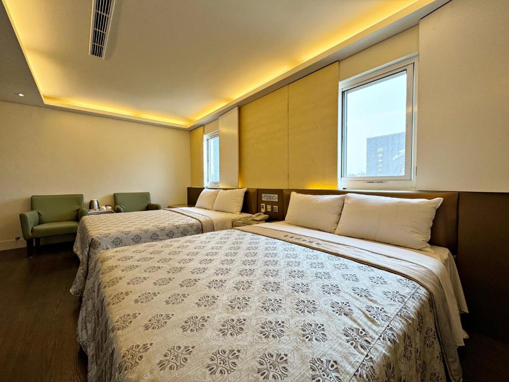 a hotel room with two beds and a window at Ai Lai Fashion Hotel in Taichung