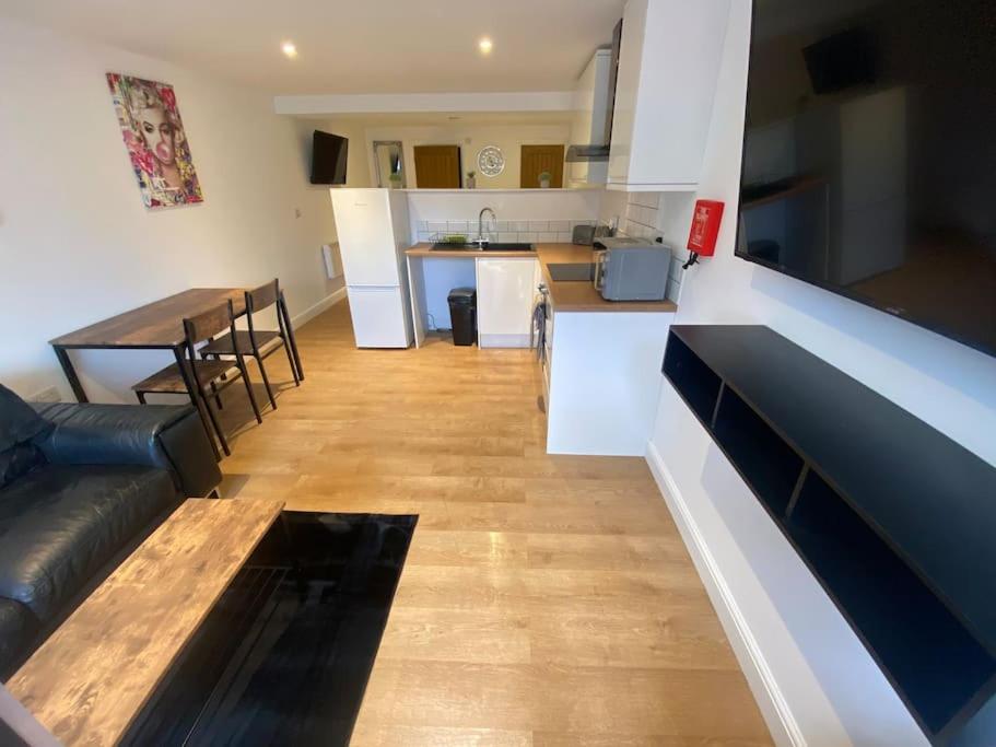 eine Küche und ein Wohnzimmer mit einem Sofa und einem Tisch in der Unterkunft LT Apartments 54 - Twin Bed Apartment in Leicester