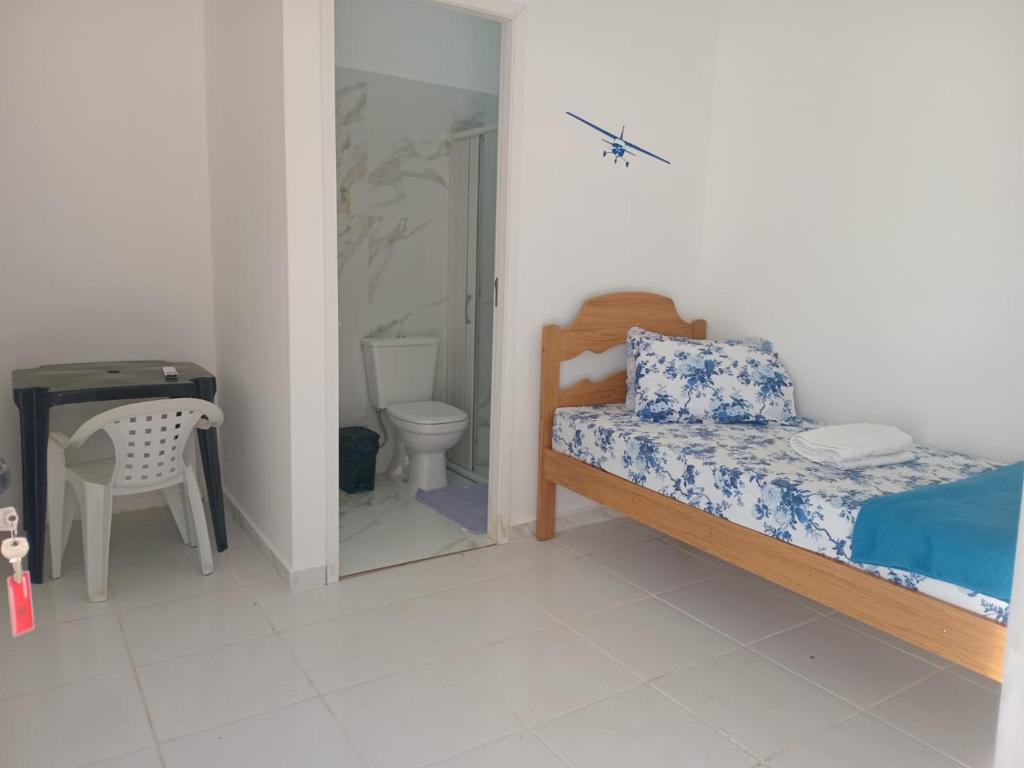 a bedroom with a bed and a toilet and a mirror at POUSADA DAS NAÇÕES lll in Indaiatuba