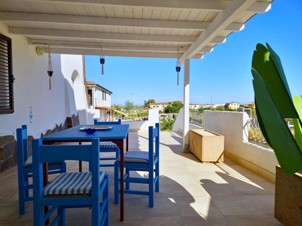 une table bleue et des chaises sur le balcon d'une maison dans l'établissement Casa Marta, à Orosei