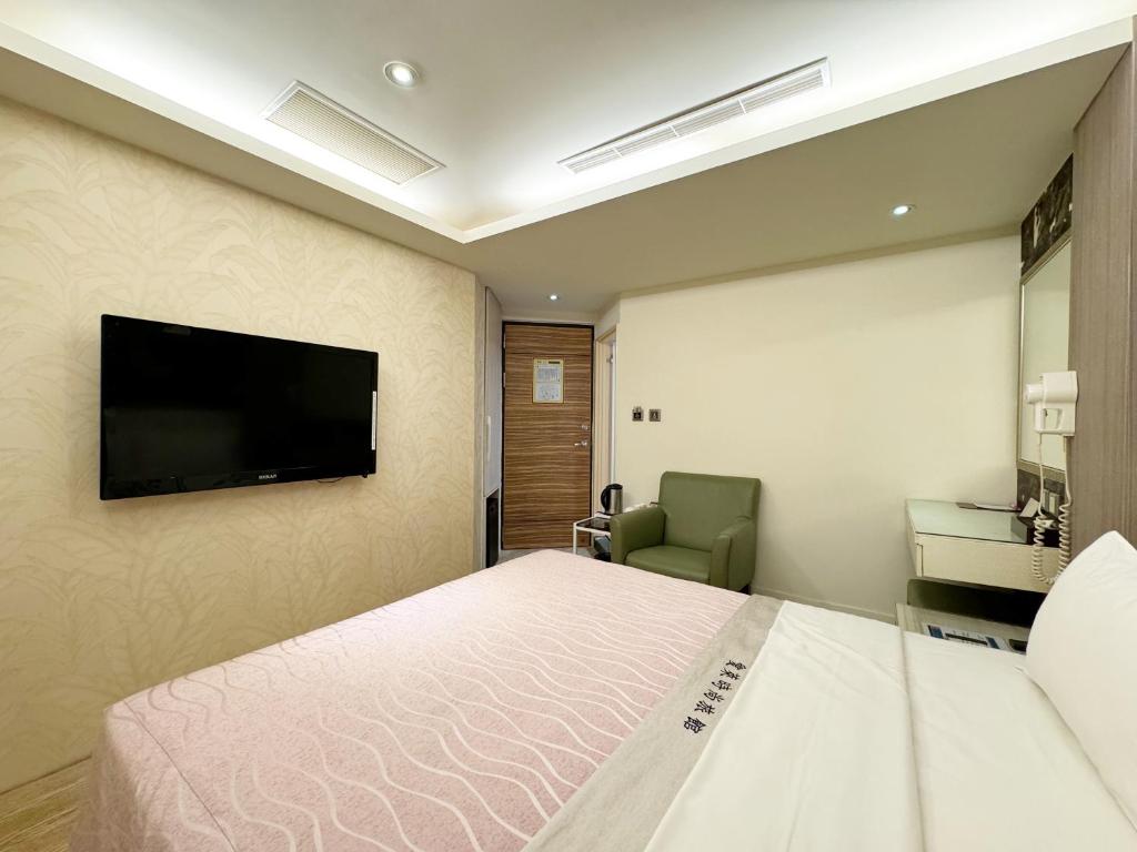 a hotel room with a bed and a flat screen tv at Ai Lai Fashion Hotel in Taichung