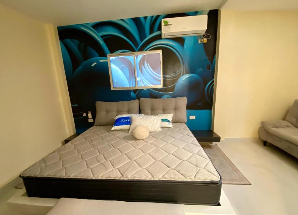 1 dormitorio con 1 cama con una pintura en la pared en Hermosa suite 3 elegante con jacuzzi, en Guayaquil