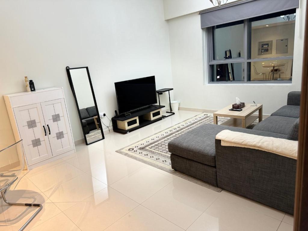 a living room with a couch and a flat screen tv at 1 BHK in Al Khan Sharjah in Sharjah