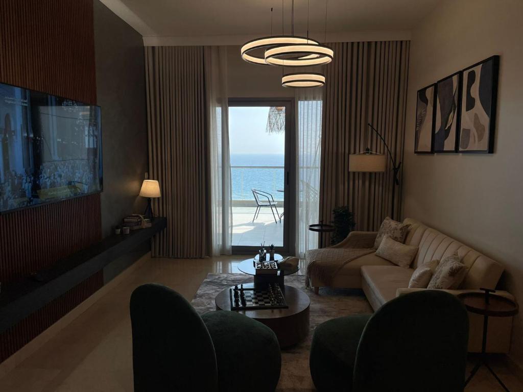 a living room with a couch and a view of the ocean at Damac Tower Jeddah apartment in Jeddah