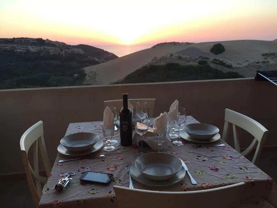 托雷戴科爾薩里的住宿－Mare, dune, lago e bosco in assoluto relax.，一张带盘子和玻璃杯的桌子和一瓶葡萄酒