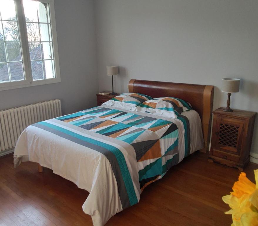 a bedroom with a bed with a colorful blanket at Chambre chez l'habitant, au calme, à 2 pas de Paris in Sucy-en-Brie