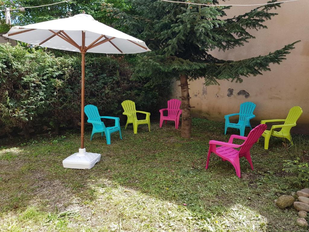 - un groupe de chaises colorées et un parapluie dans l'établissement l'étape DECAZEVILLE, à Decazeville