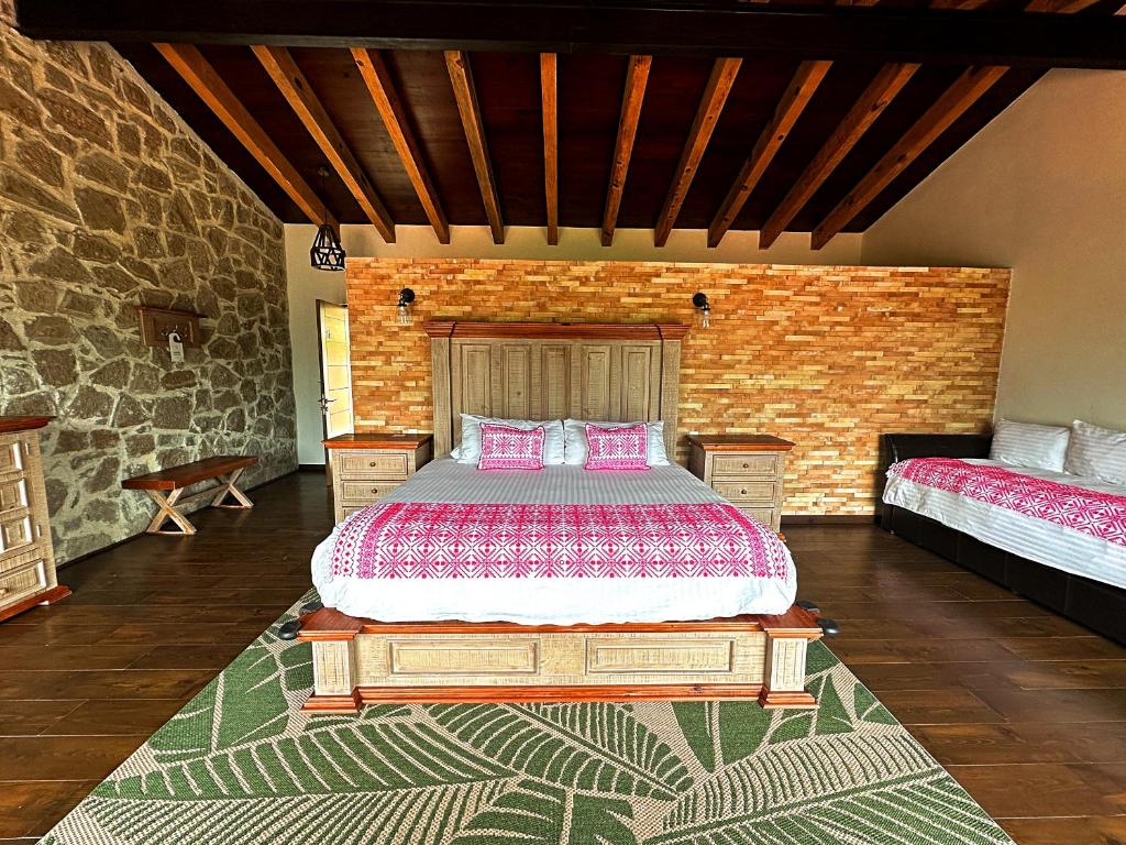 1 dormitorio con cama y pared de ladrillo en Hotel Casa Xaa en Tlatlauquitepec