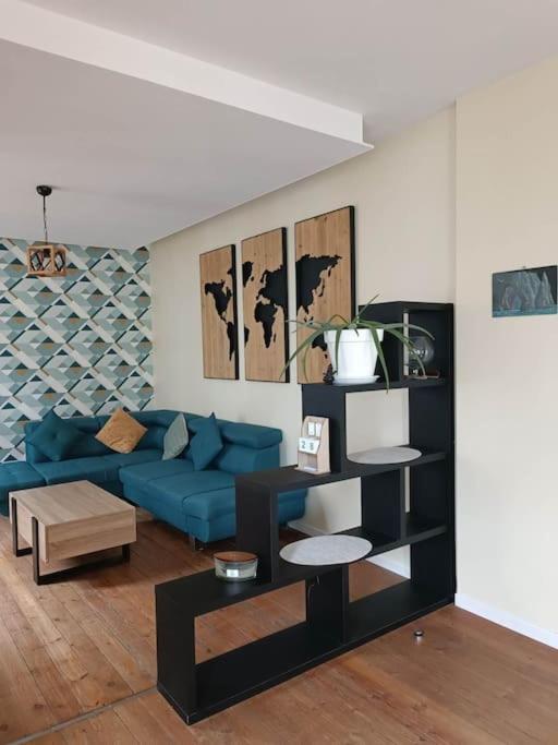 un salon avec un canapé bleu et une table dans l'établissement Maison au cœur du village avec parking, à Étretat