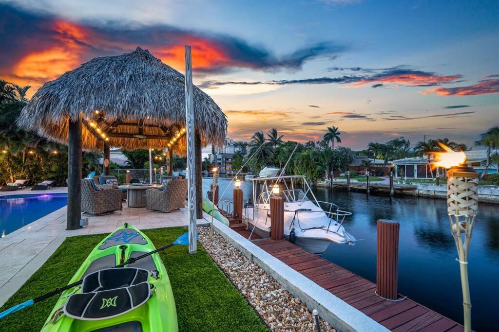 a resort with a pool and a boat in the water at Near Beach/kayaks/HtdPool/Tiki/BBQ/Gameroom in Pompano Beach