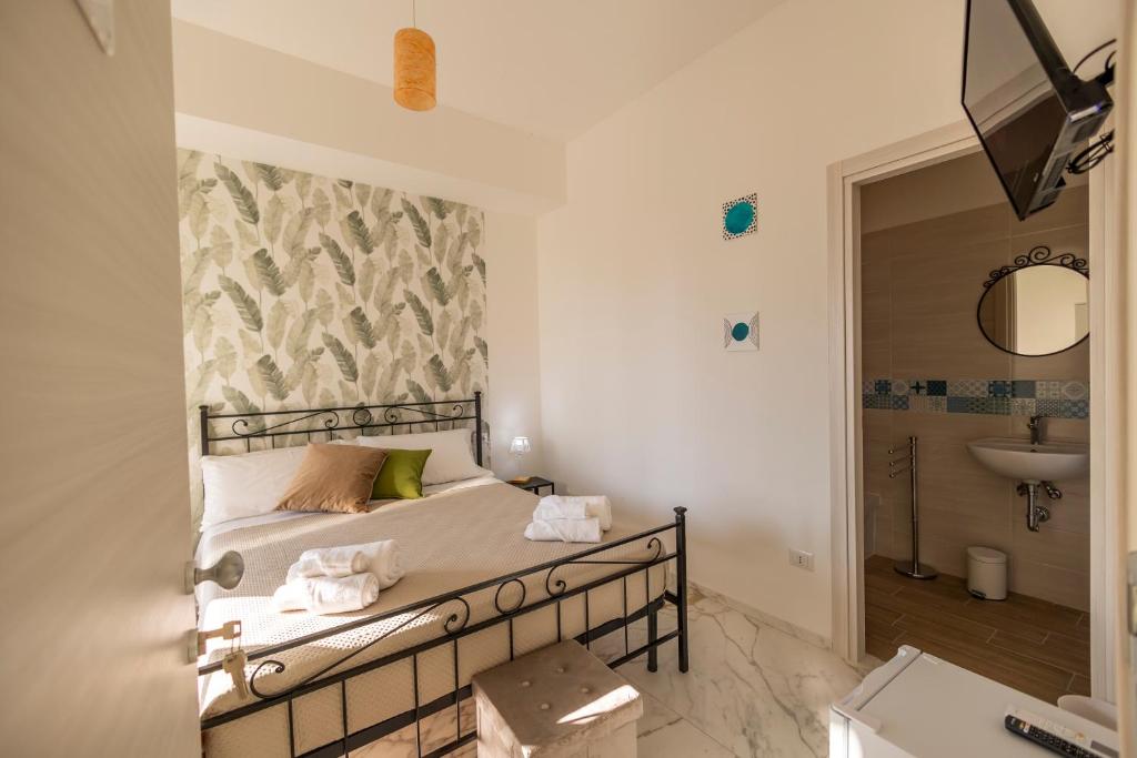 1 dormitorio con 1 cama y baño con lavamanos en Cientopera Suite Rooms, en Pontecagnano Faiano