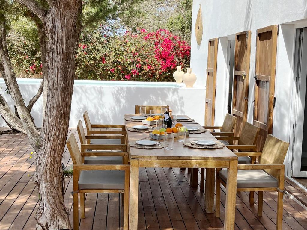 a wooden table and chairs on a patio at Formentera Mind Yoga & Fit in Playa Migjorn