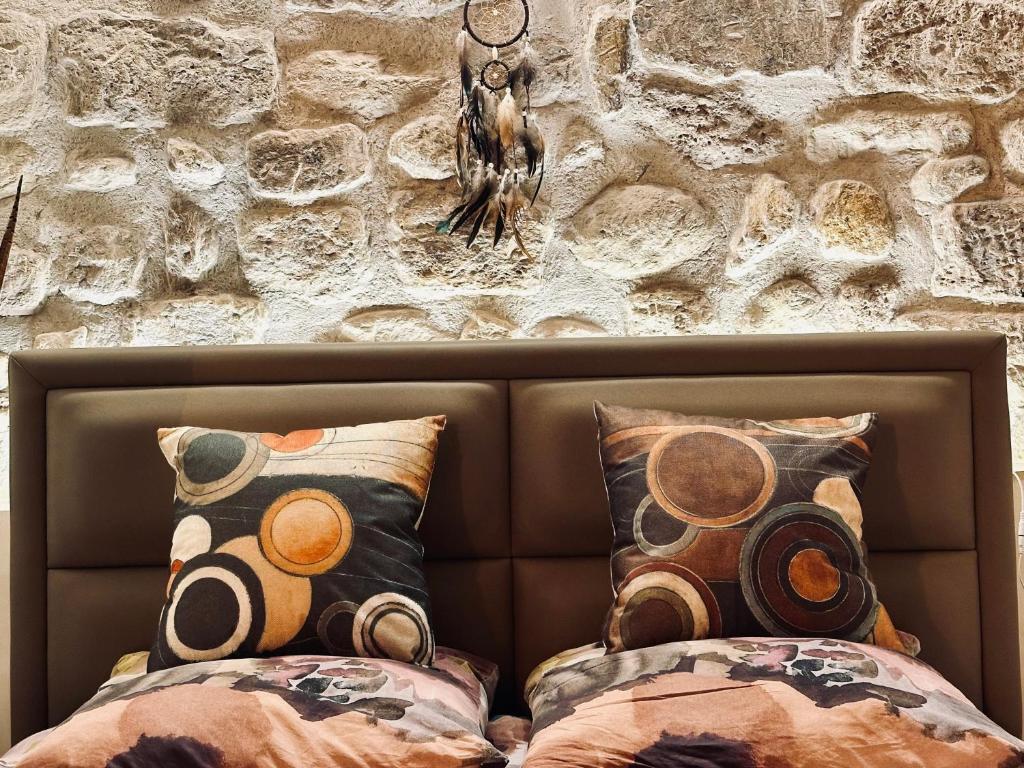 a headboard with pillows and a stone wall at New Studio design by KENZO with Jacuzzi in Paris