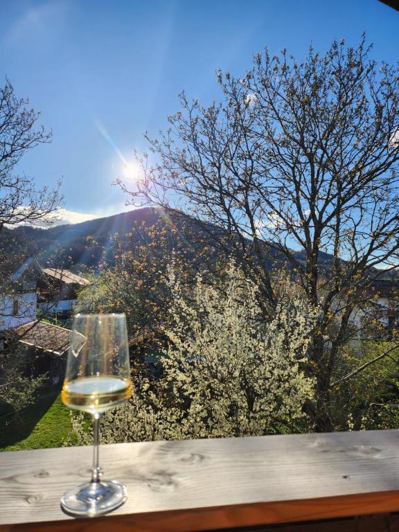 a glass of wine sitting on a table with a view at Ferienhaus Bad Feilbach in Bad Feilnbach