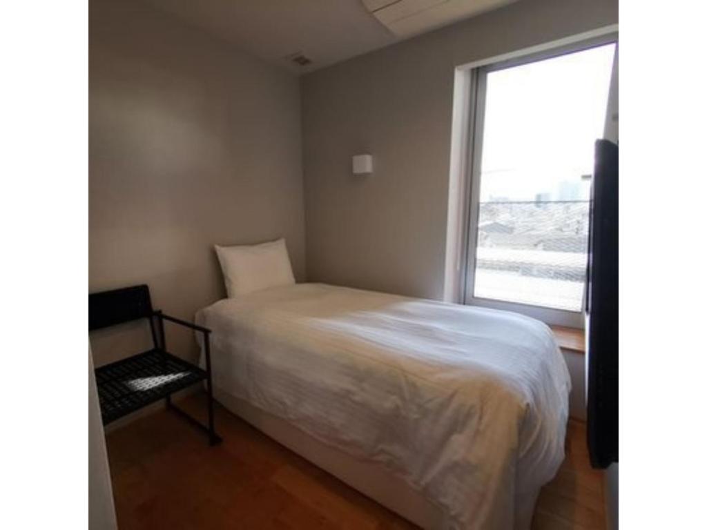 a small bedroom with a bed and a window at Hotel Discover Nagaokakyo - Vacation STAY 34389v in Nagaokakyo