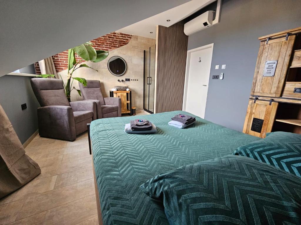 a bedroom with a bed and a living room with a couch at Gezond aan Zee, Zeeschelp, wellnesstuin tegen meerprijs in Ouddorp