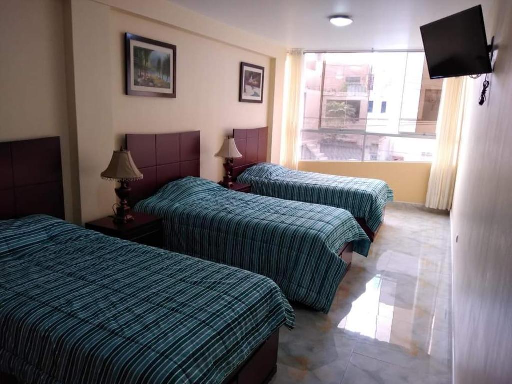 a hotel room with two beds and a television at VALERY in Trujillo