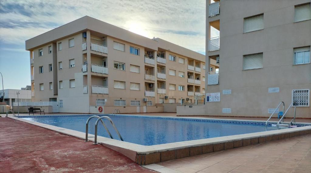 een gebouw met een zwembad voor een gebouw bij Miami Platja cerca del mar in Miami Platja