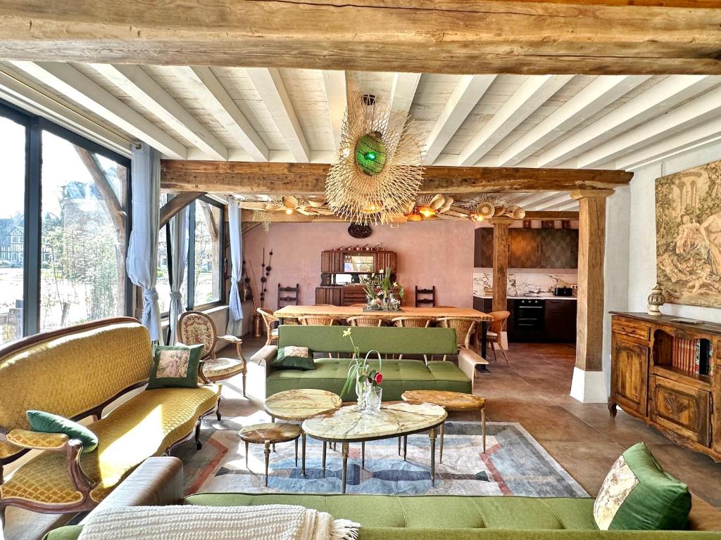 Elle comprend un salon doté d'un mobilier vert et d'un lustre. dans l'établissement Château de Saint-Clair, à Étretat