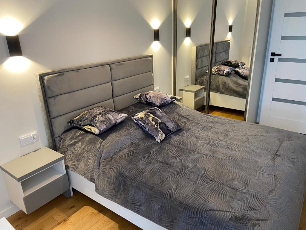 a bedroom with a large bed with two pillows at APARTAMENT AURA RYBAKI in Gdańsk