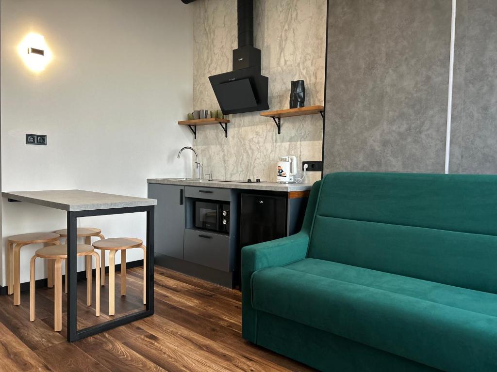 a living room with a green couch and a table at Apartments in Grani in Dnipro