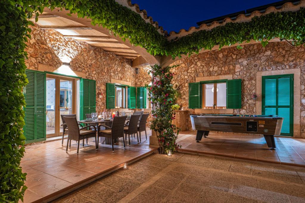 a dining room with a ping pong table and green shutters at Finca Girasols in Campos