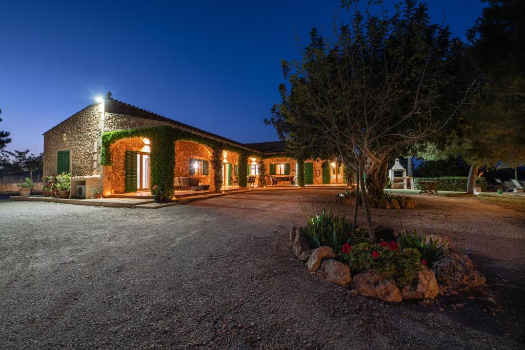 a house with a tree in front of a driveway at Finca Girasols in Campos