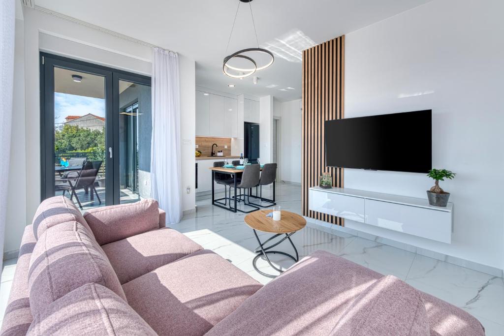 a living room with a couch and a tv at Sea Star Apartment in Cavtat