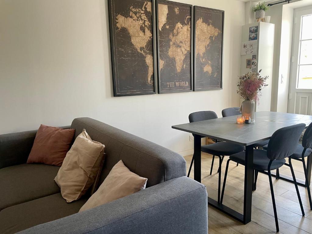 sala de estar con sofá y mesa en Maison fraîchement rénovée, en Saint-Pierre-de-Plesguen