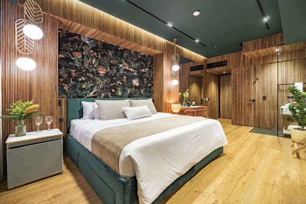 1 dormitorio con 1 cama grande y una pintura en la pared en Selvario 36 Hotel en Medellín