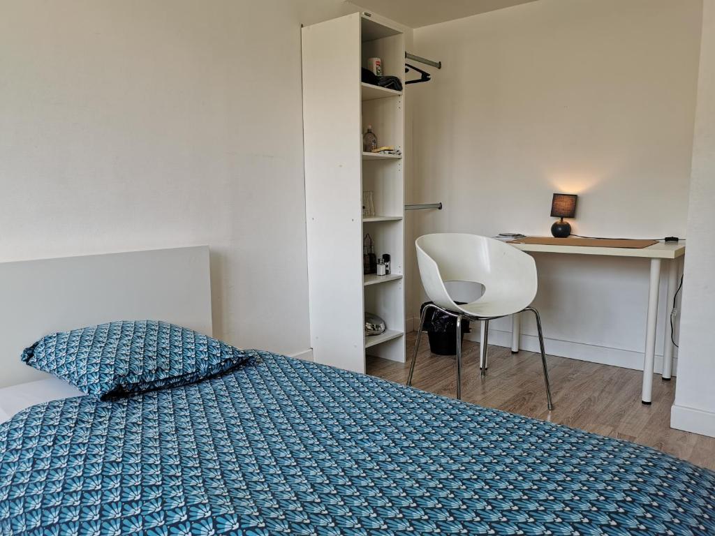 una camera con letto, scrivania e sedia di Belle chambre exposée Sud a Le Havre