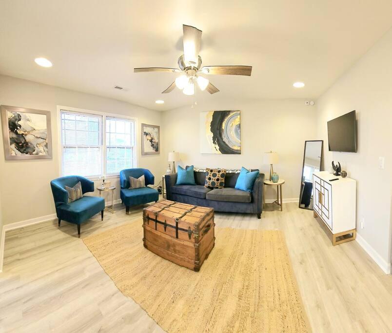 a living room with a couch and chairs and a ceiling fan at Chic Oasis: 3BR, 2BA, Private Deck in Charleston