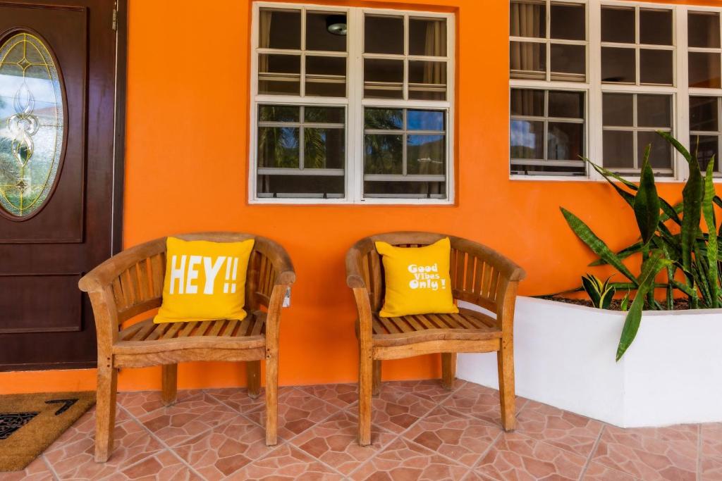2 Stühle mit gelben Kissen vor einem Haus in der Unterkunft The Vintage Charm in Cliftons